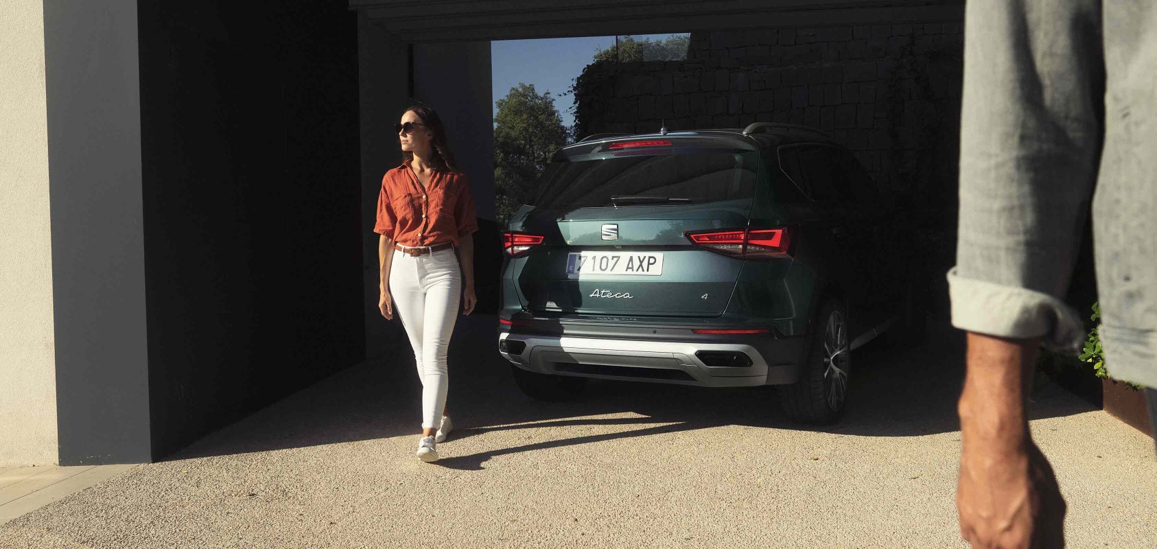 Woman standing next to the new SEAT Ateca dark camouflage with full rear led lights