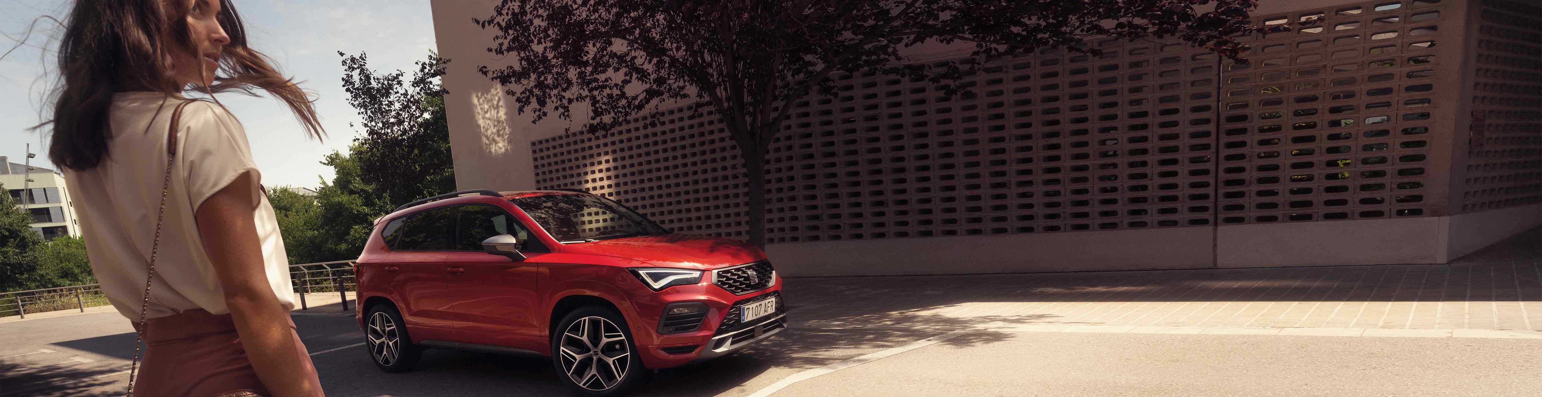Woman walking to the new SEAT Ateca velvet red colour