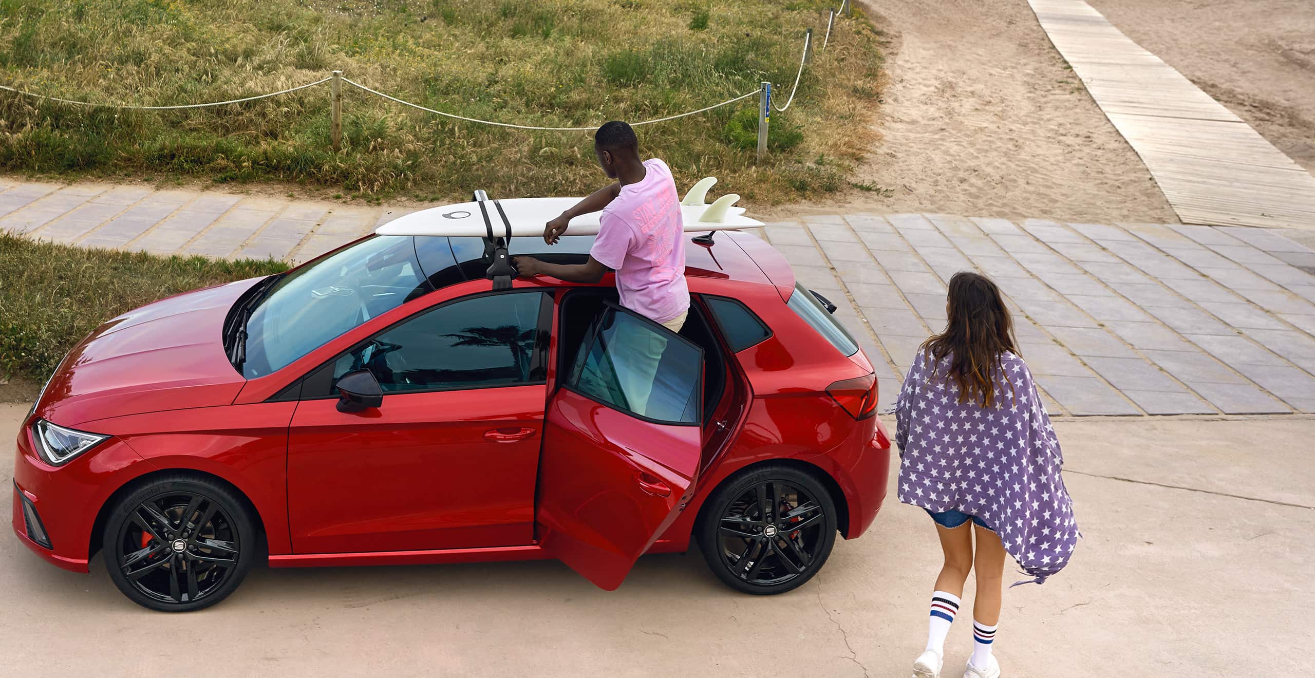 Home instal·lant un rack de surf al SEAT Ibiza