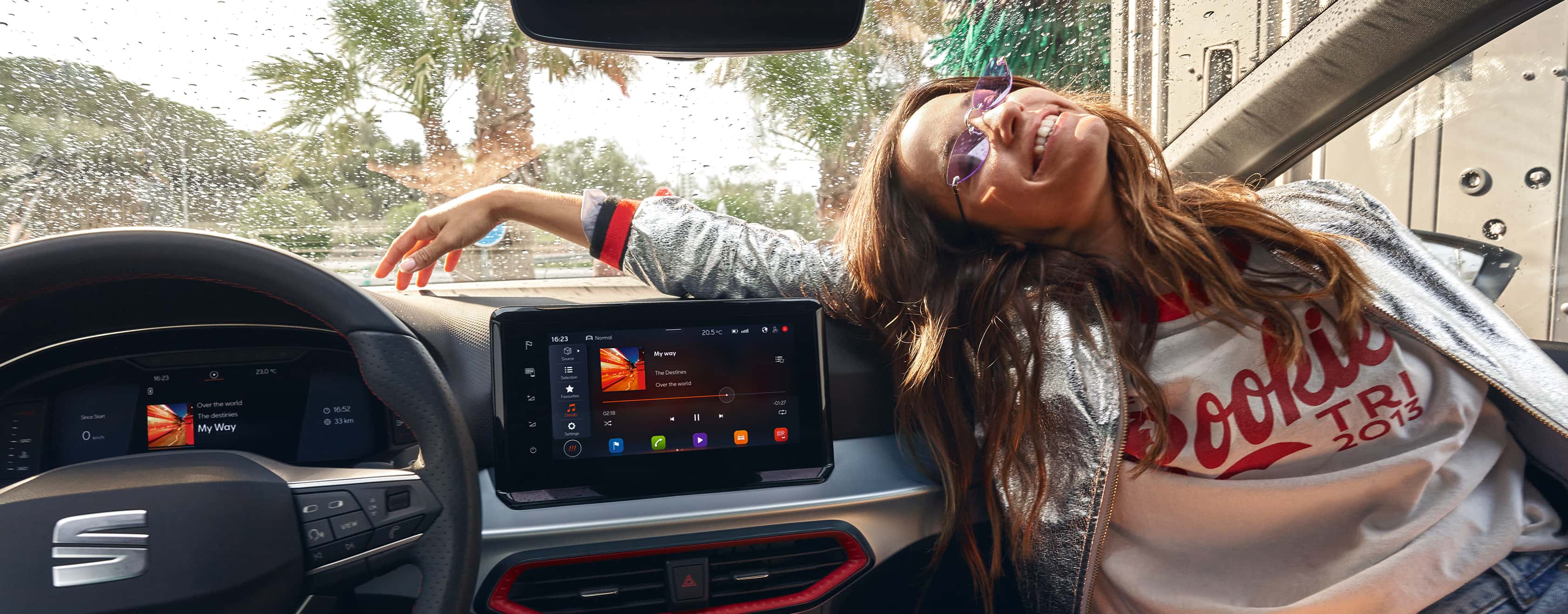 Dona asseguda dins d'un SEAT Ibiza al costat de la pantalla tàctil flotant de 9,2 "